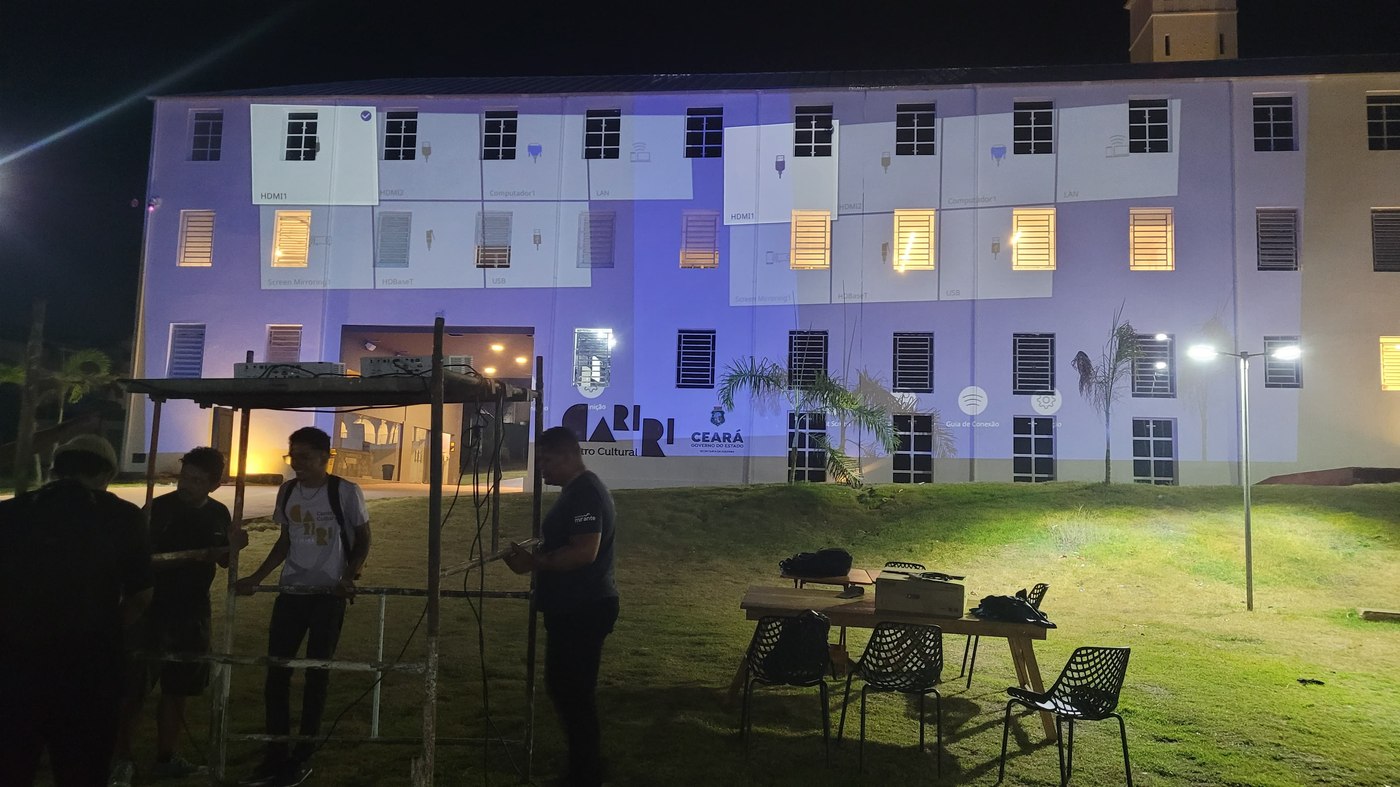 Dois projetores sobrepostos com os menus de conexão Epson ainda visíveis na fachada