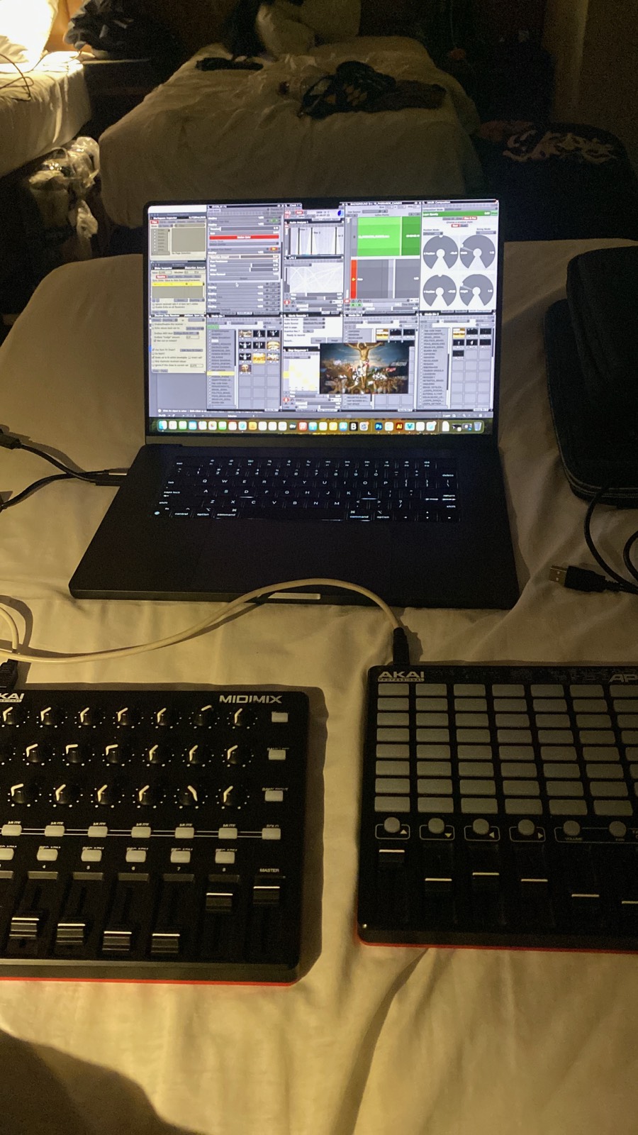 Setup técnico montado em cima da cama da pousada: laptop com software de VJing e controladores Akai