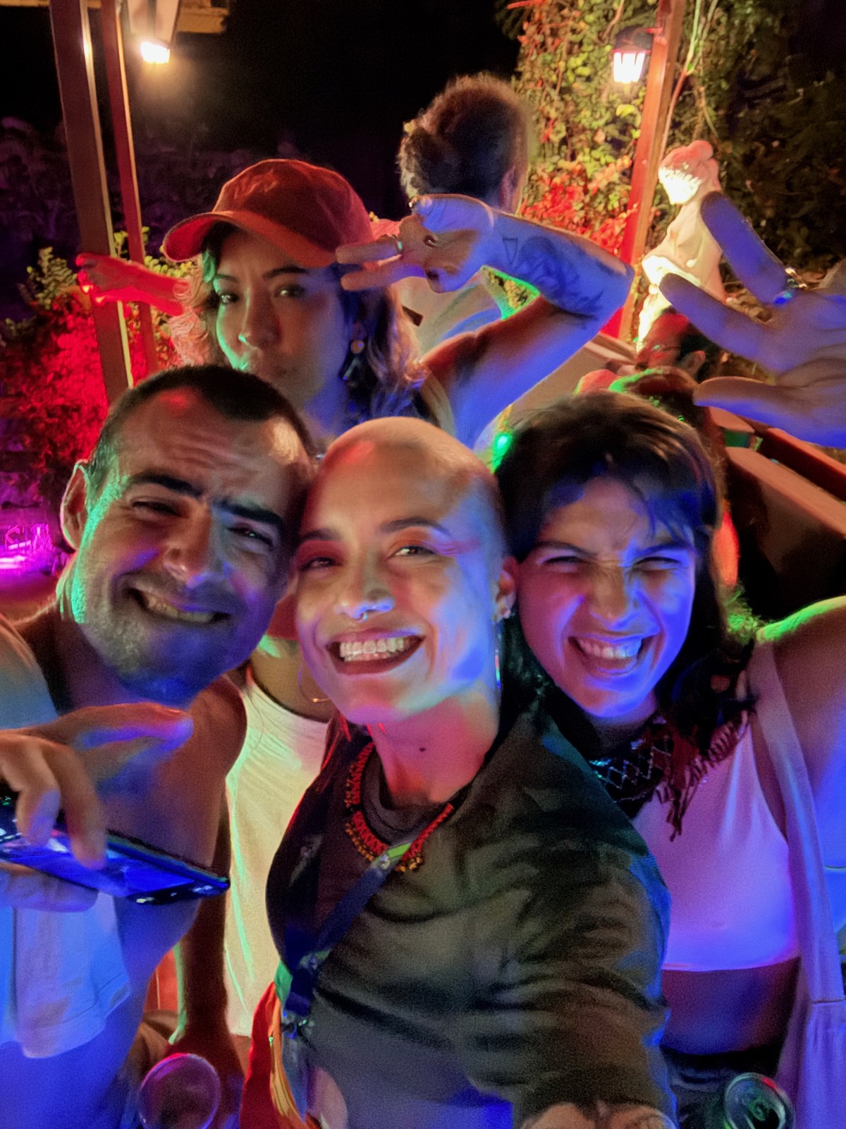 Grupo de amigos reunido de noite, luzes coloridas