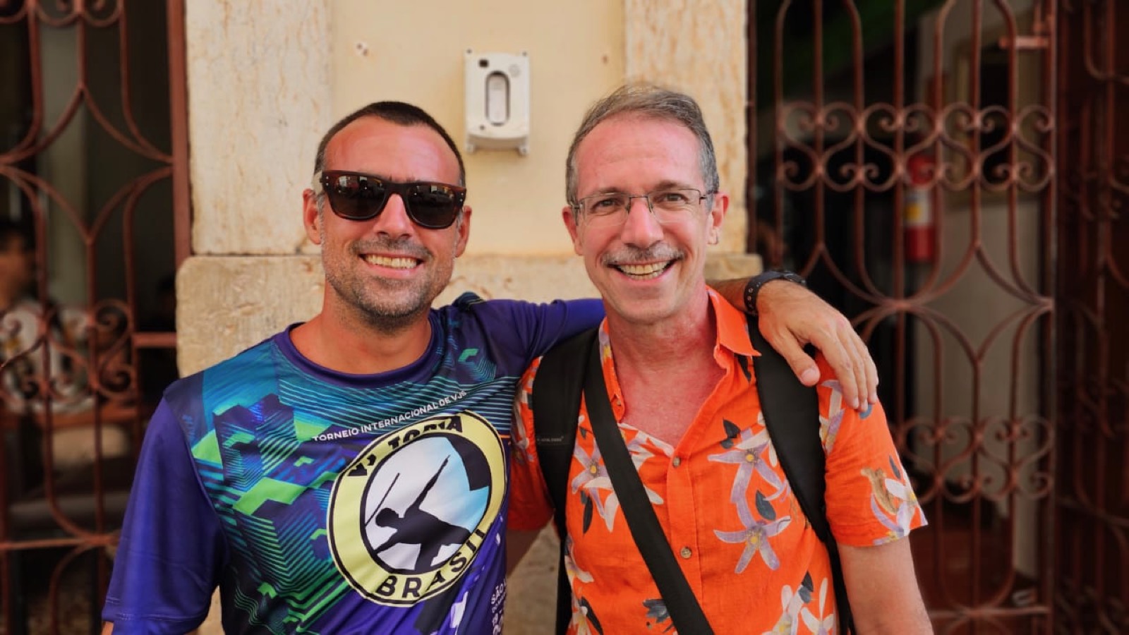 Selfie em dupla de dia, na entrada da pousada, amigo usando a camiseta oficial do torneio