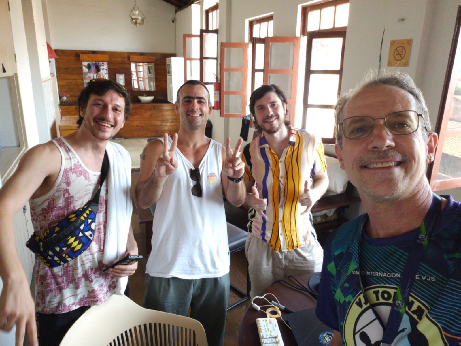 Grupo de quatro amigos de dia, na área comum da pousada