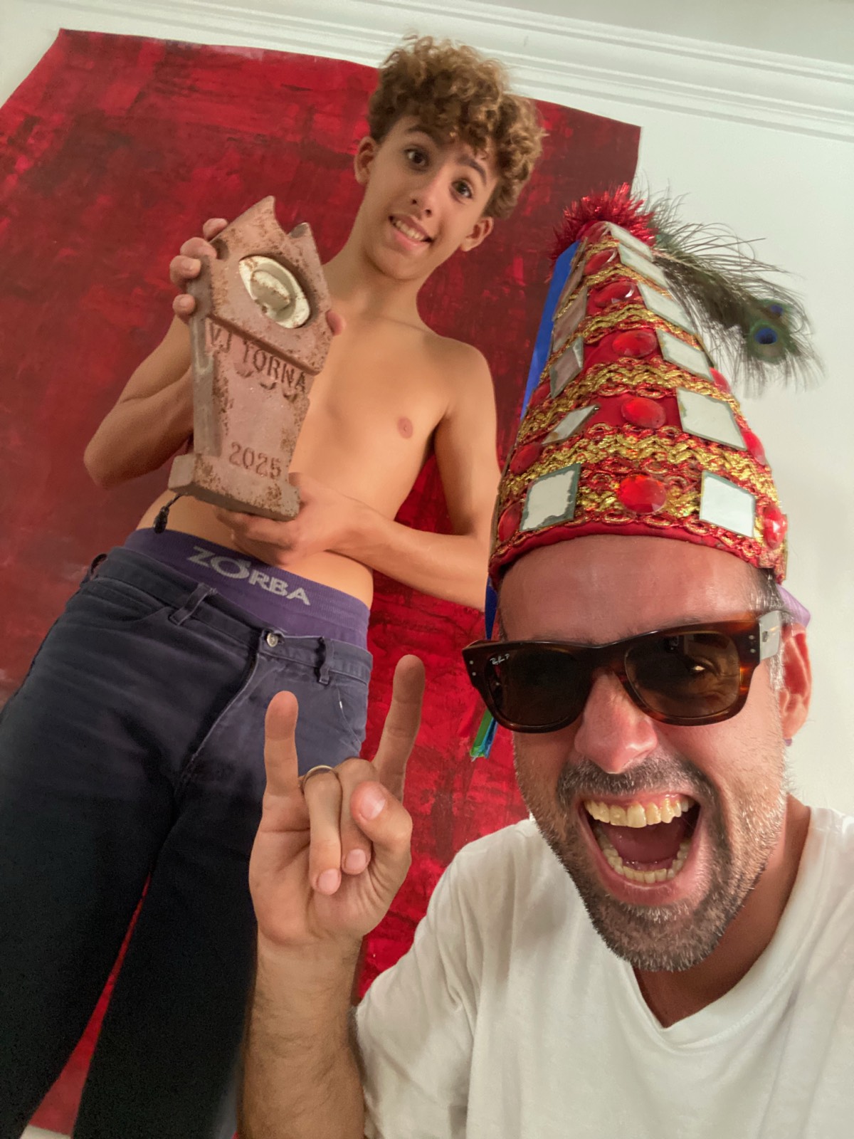Selfie em dupla já de volta, segurando o troféu do torneio